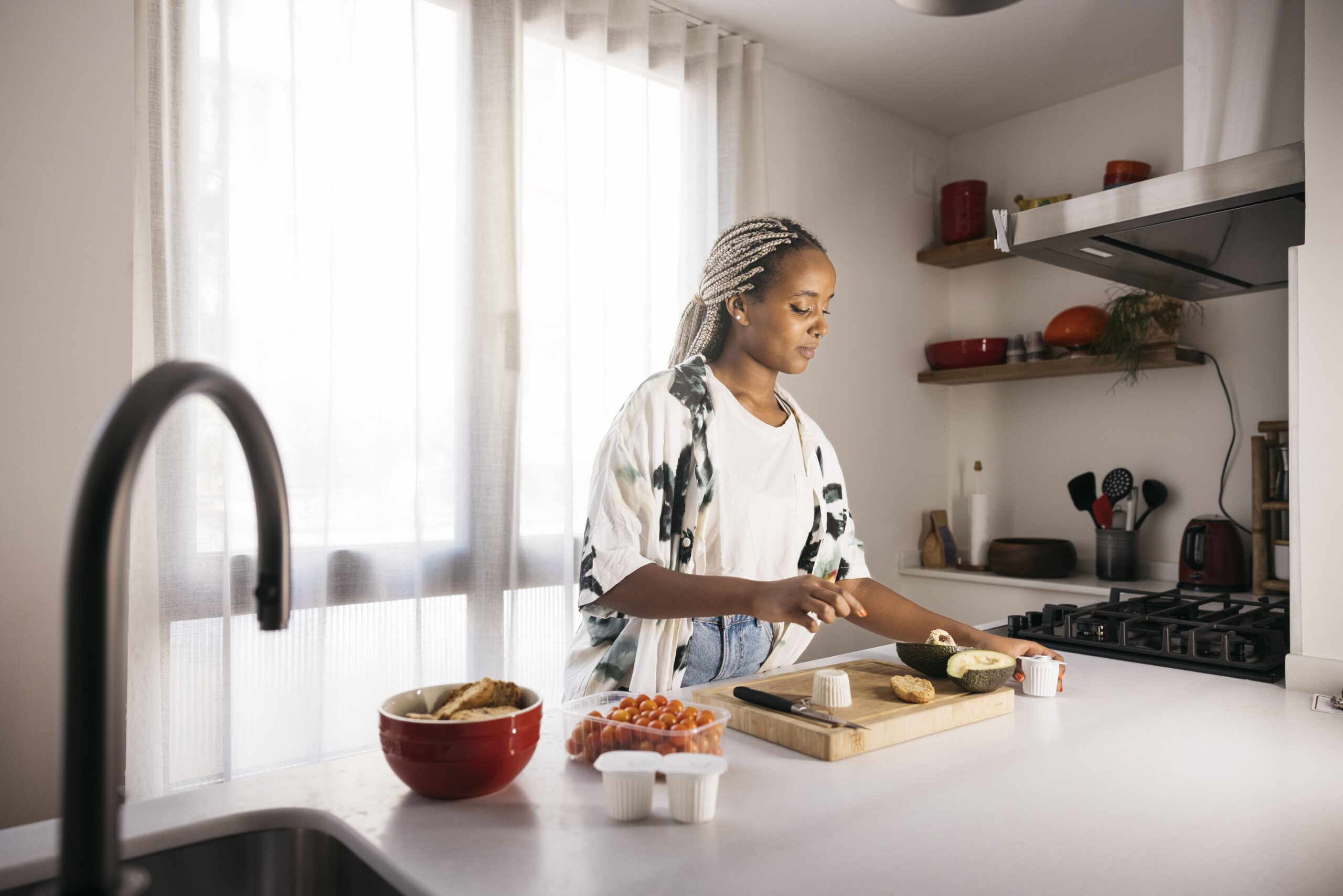 An adult calmly preparing a simple meal in a quiet kitchen, reflecting the thoughtful and individualized nature of managing persistent IBS symptoms